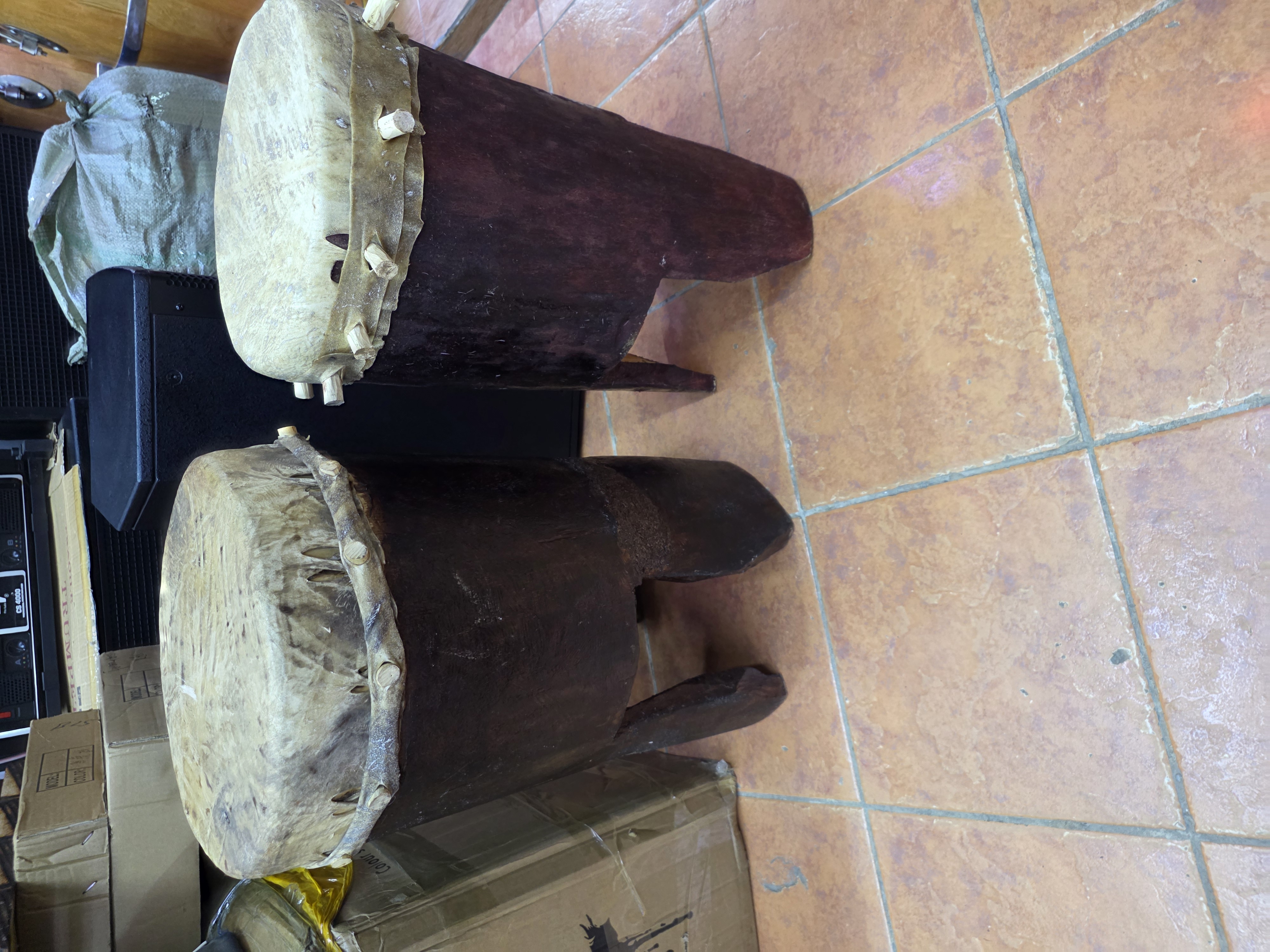 "Handcrafted Mabumbumbu traditional drum from Kenya featuring a single-headed cylindrical wooden body with animal skin drumhead, producing deep bass tones and used by the Giriama people of the Mijikenda community for cultural ceremonies, traditional dances, and performances. Available at Musicland Music Shop."
